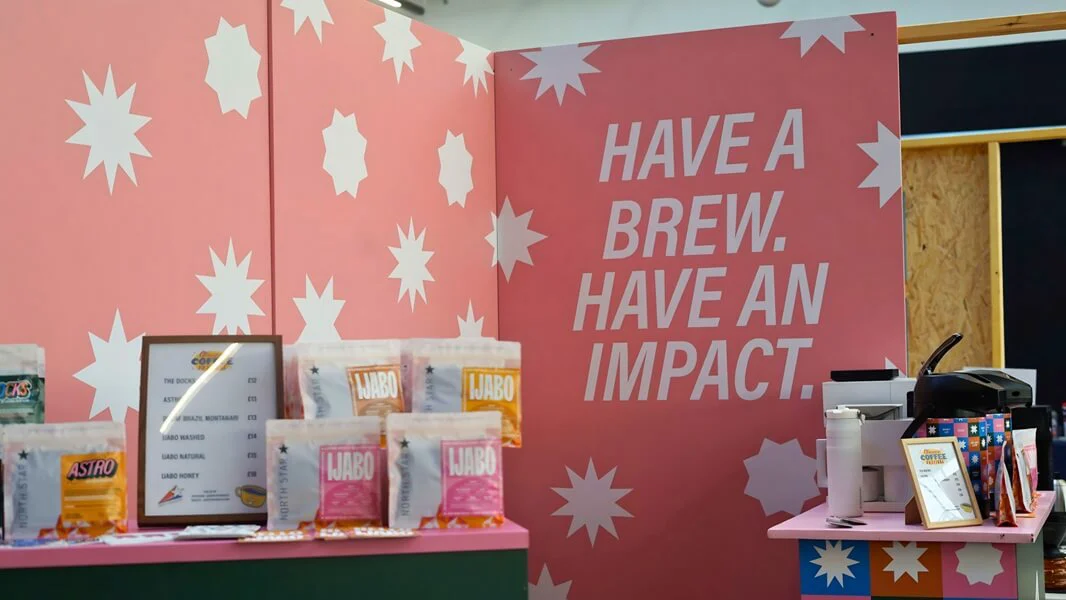 An image of the "Have a Brew. Have an Impact." pink and white wall mural.